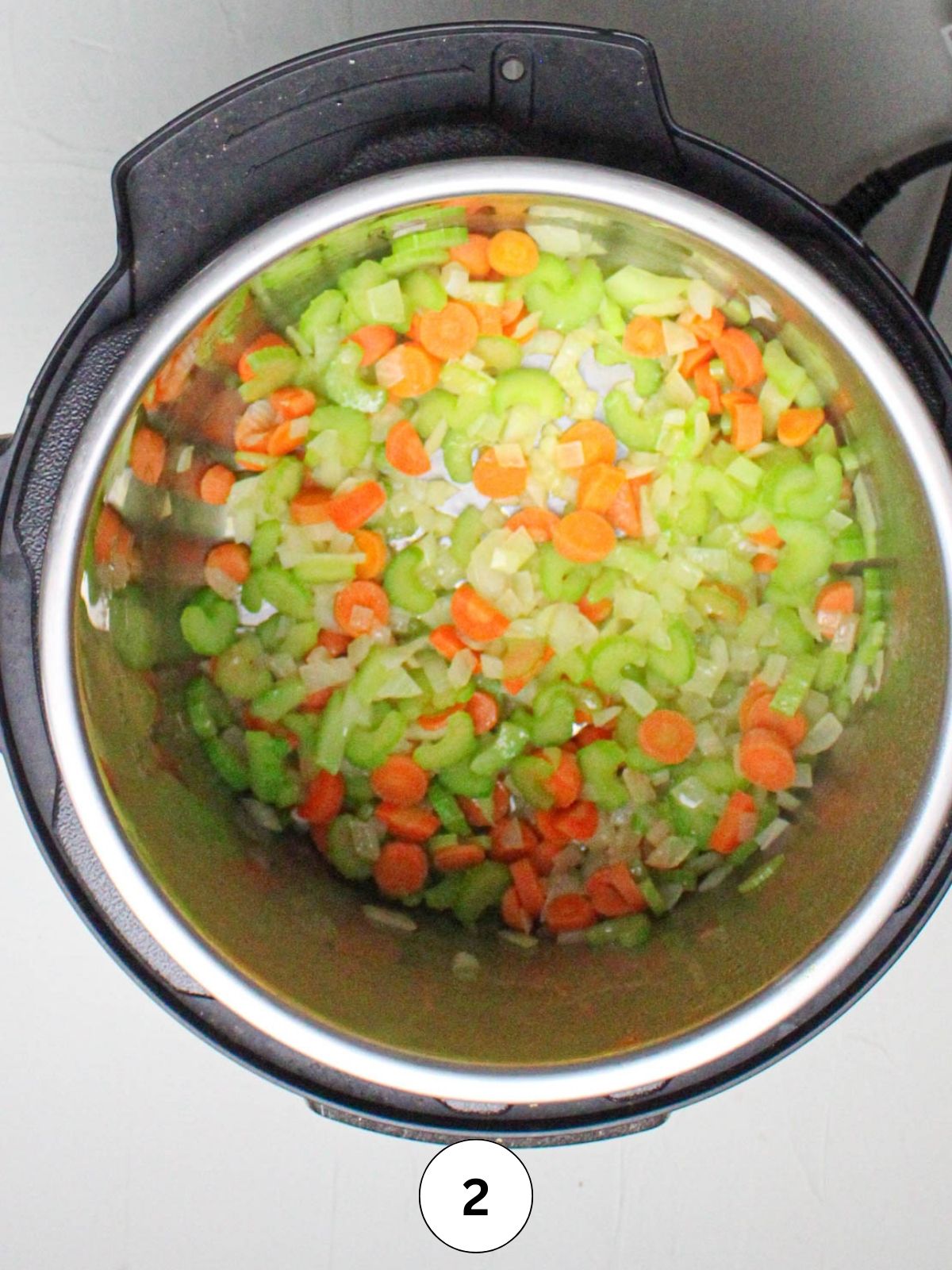 Instant Pot with sautéing onions, carrots, and celery.